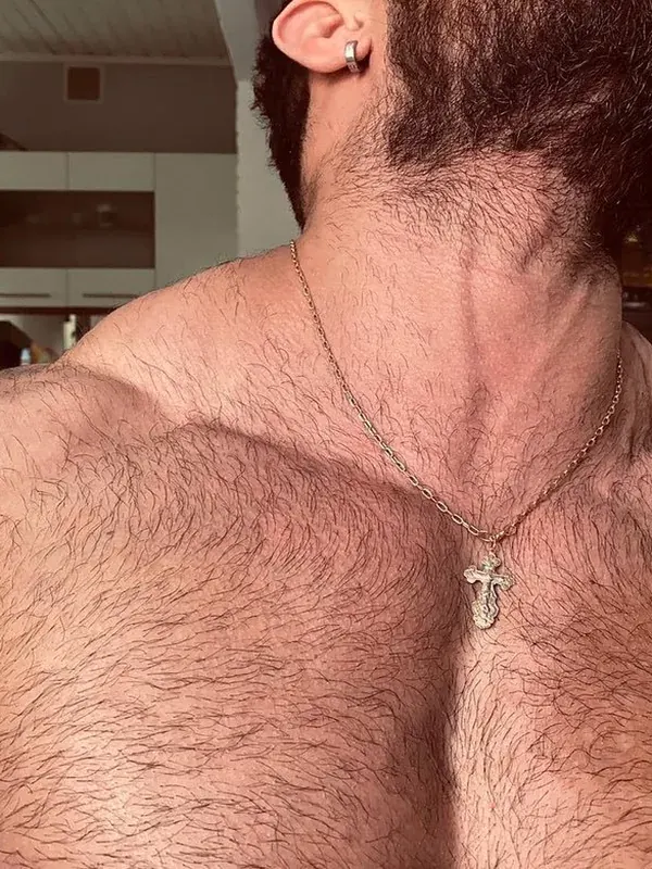 Dos nu musclé avec chaîne et croix, vue arrière, intérieur moderne